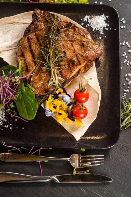 Steakgericht aus gegrilltem Marmor auf schwarzem Hintergrund