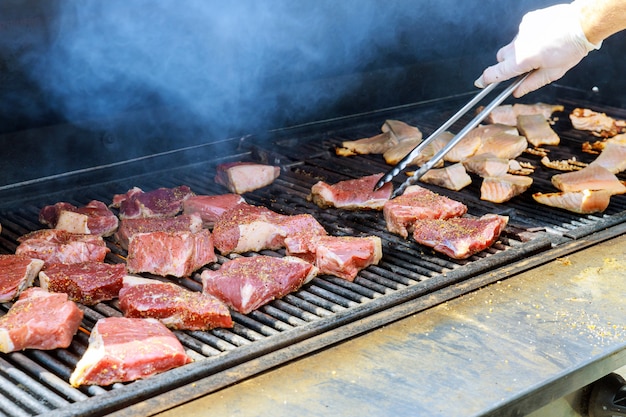 Steaks mit Salz und Pfeffer auf einem Grill im Freien gewürzt