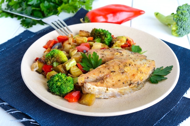 Steaks von gebratenem würzigem Fisch, serviert mit einem warmen Gemüsesalat