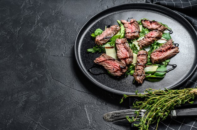 Steaksalat mit Spinat, Rucola und geschnittenem Rindfleisch Striploin Steak.