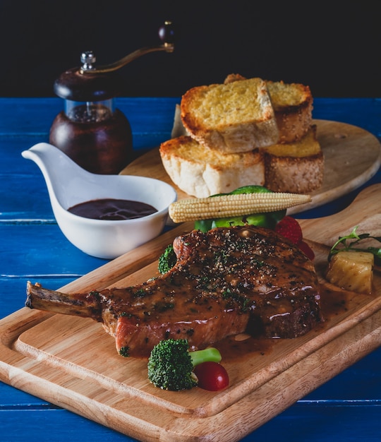 Steakschweinekotelett mit Gemüse auf hölzernem Brett