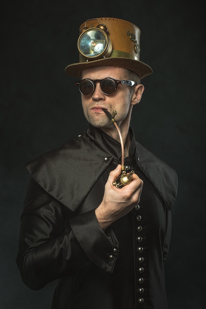 Steampunk hombre con sombrero fumando una pipa