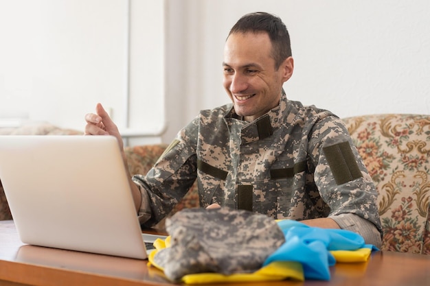 Stehen Sie mit der Ukraine auf Social Media-Konzepthintergrund mit Laptop. Militär mit der Flagge der Ukraine