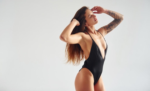 Stehend und posierend Schöne verführerische sportliche Frau mit sexy Körper ist im Studio