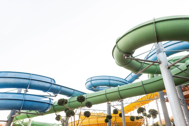 Steile Wasserrutschen mit farbigen Rohren und Tunneln im Wasserpark. Sommerurlaub