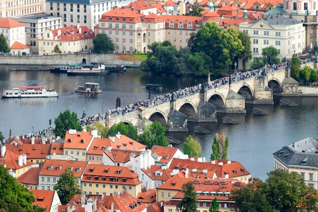 Steinbrücke mit den Menschen und dem Fluss in einer wunderschönen Altstadt mit roten Ziegeldächern