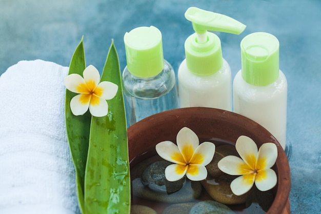 Steine Blumen und Flasche Kosmetik für Massagebehandlung auf hellem Hintergrund