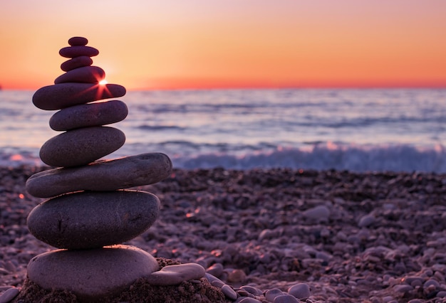 Foto steinhaufen am strand bei sonnenuntergang