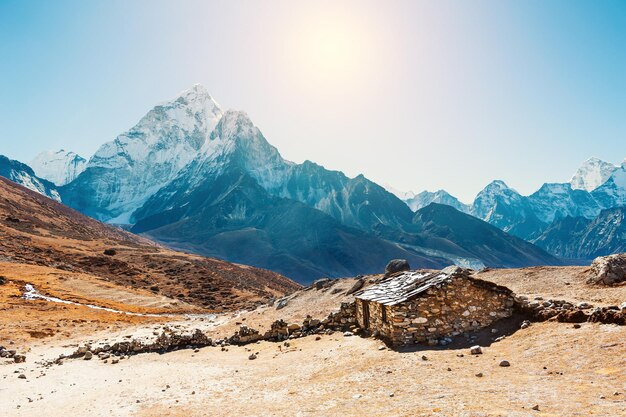 Steinhaus in den Bergen und Blick auf den Berg Ama Dablam im Himalaya, Nepal. Everest Base Camp Trek, Sagarmatha Nationalpark