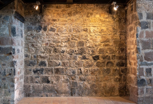 Steinmauer eines Kircheninnenraums mit beleuchteten Scheinwerfern
