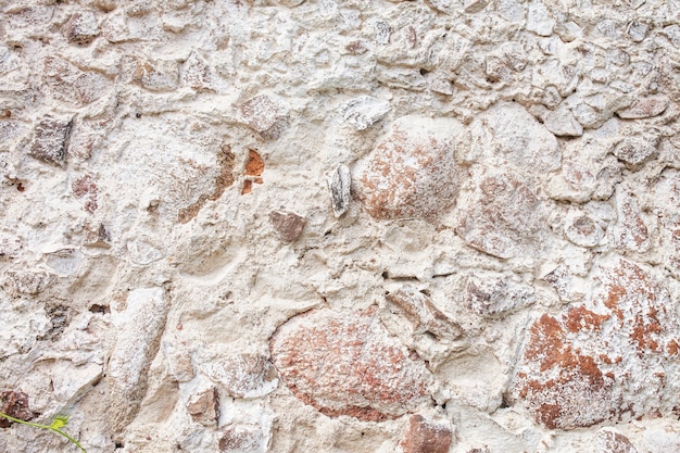 Steinmauer Textur. Mosaikfelsen dekorativer Wandhintergrund. Mauer aus alten Steinen. Dekorative Verkleidung der Außenwände des Hauses.