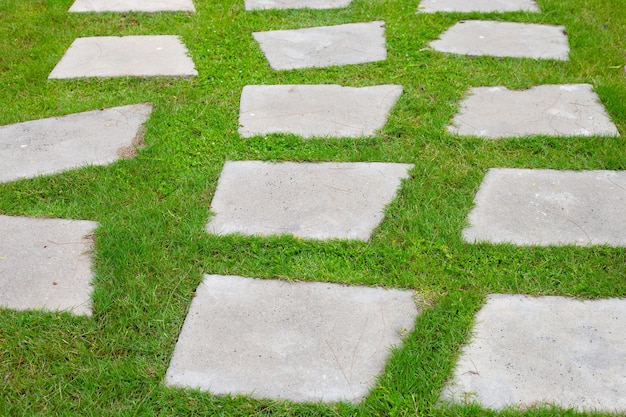 Steinpfad auf grünem Gras im Garten