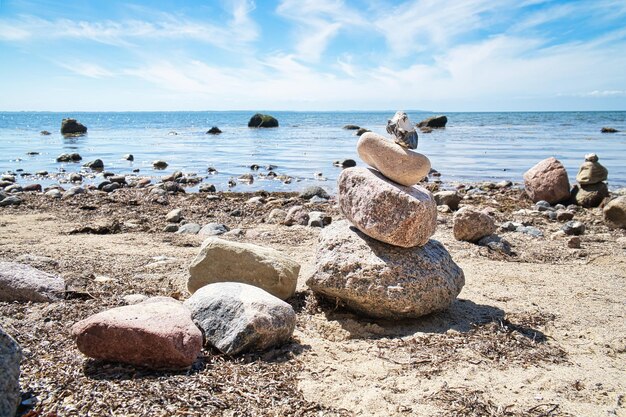 Foto steinpyramide an der ostsee mit blick auf blauen himmel und spirituellen sonnenschein