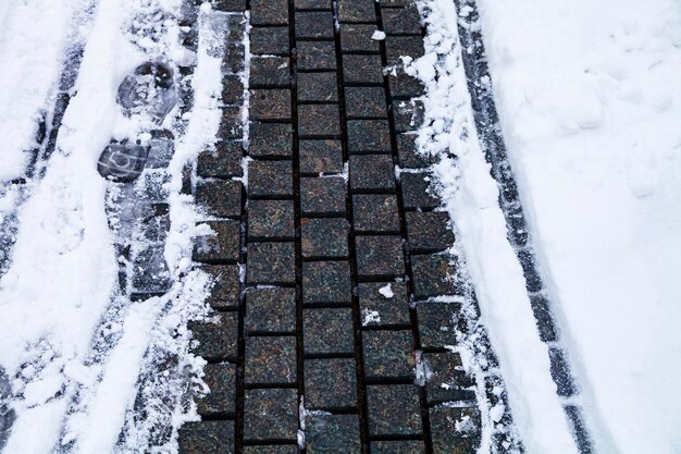 Foto steinweg im park in der schneenahaufnahme. winter in der stadt.