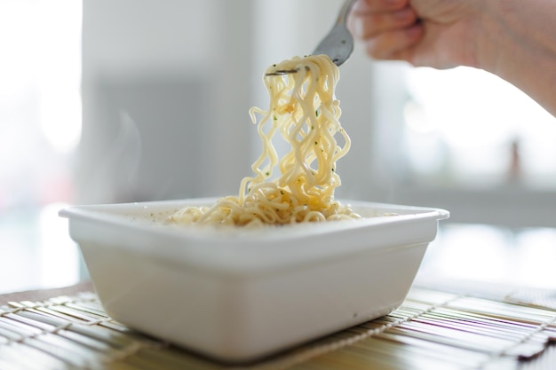 Stellen Sie sich eine Gabel in den Händen von jemandem vor, der sich Fast Food hingibt