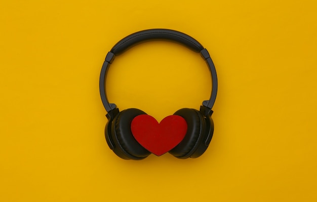 Stereo-Kopfhörer mit Herz auf gelbem Hintergrund. Musikliebhaber
