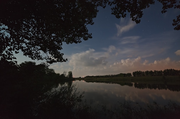 Foto sterne am himmel mit wolken. nachtlandschaft mit see.