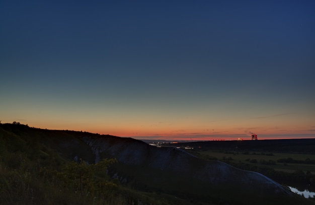 Sterne des Weltraums am Nachthimmel über dem Flusstal. Landschaft in der Dämmerung bei Langzeitbelichtung.