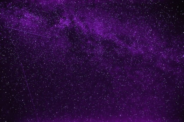 Sternschnuppen im Hintergrund ein lila Nachthimmel und die Milchstraße