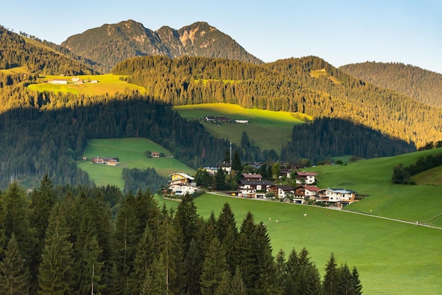 Österreichisches Dorf auf dem Hintergrund der Alpen