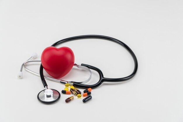 Stethoskop, Pillen und Spielzeugherz. Konzept Gesundheitswesen. Kardiologie - Pflege des Herzens