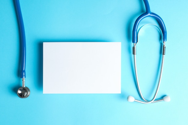 Foto stethoskop und notizblock auf blauem hintergrund, platz für text