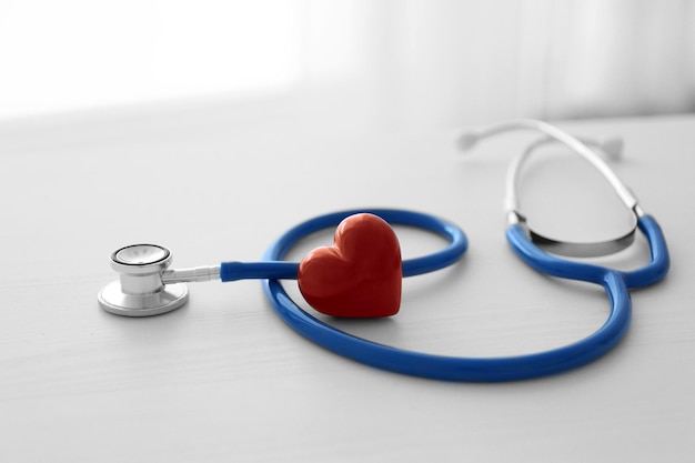 Stethoskop und rotes Herz auf dem Tisch