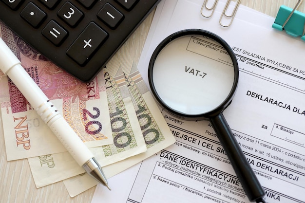 Foto steuererklärung auf waren- und dienstleistungssteuer, mwst-formular auf buchhaltungstabelle mit stift und polnischer zloty