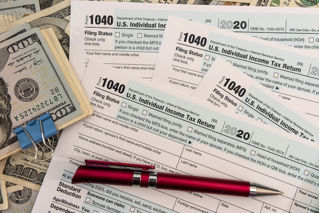 Steuerformular 1040 mit uns 100-Dollar-Banknoten, Wirtschaftsprüferkonzept