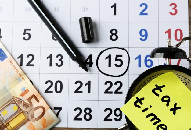 Foto steuerzeit auf wecker mit euro-marker und kalender