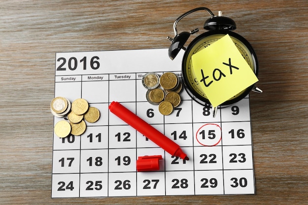 Steuerzeit auf Wecker mit Münzmarker und Kalender