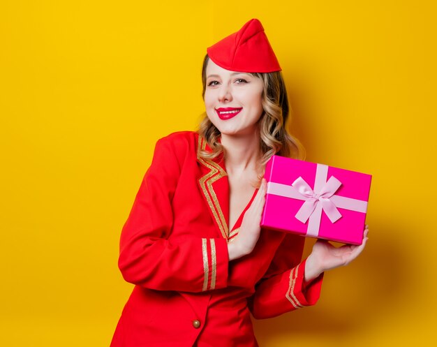 Stewardess in roter Uniform mit Weihnachtsbox