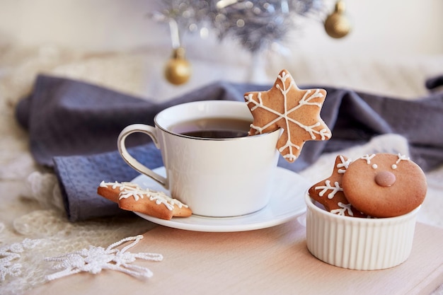 Ästhetik Feiertage Frühstück mit süßen Ingwerkeksen aus Schneeflocken und einer Tasse Kaffee Gemütlicher, warmer Hintergrund