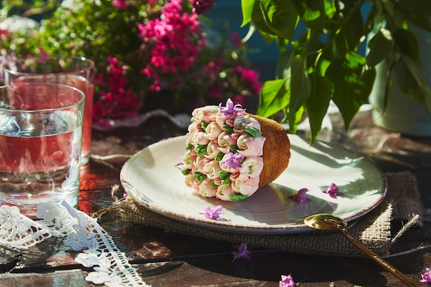 Ästhetisches Outdoor-Picknick mit Wasser und Kompott schöner Cupcake mit handgefertigten Blumen Blumen und Spitzendekoration Ländliches Picknick mit hellen Frühlingssommertönen von Blumen an einem sonnigen Tag