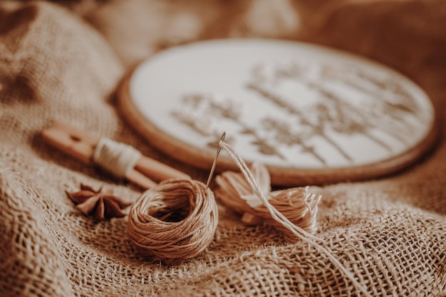 Stickset Hoop Zahnseide Fäden und Leinwand auf altem Vintage Sackleinen Hintergrund