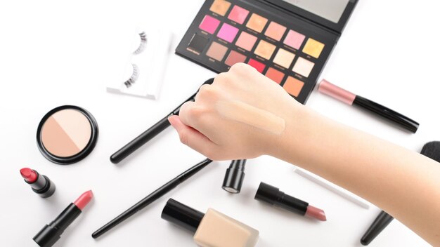 Stiftung in Frauenhänden Professionelle Make-up-Produkte mit kosmetischen Schönheitsprodukten, Lippenstift, Lidschatten, Wimpern, Pinseln und Werkzeugen