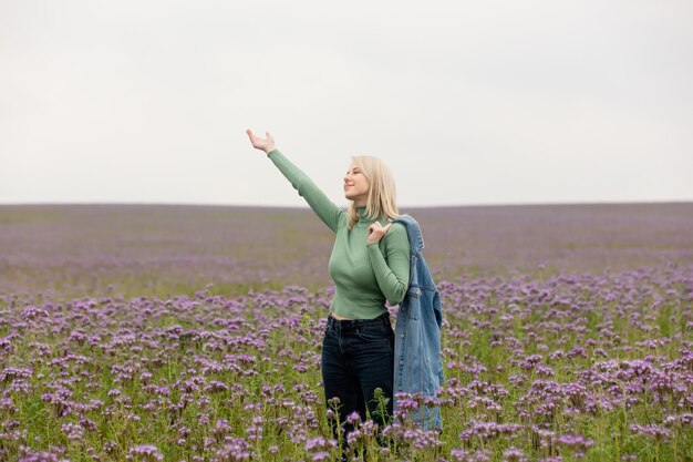 Stil blonde Frau in Blumen in der Herbstzeit abgelegt