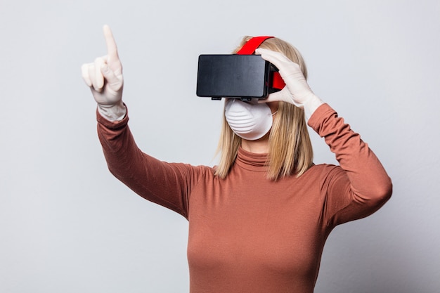 Stil blonde Frau in Gesichtsmaske mit VR-Brille