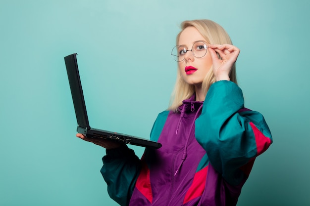 Stil blonde Frau in Gläsern mit Laptop-Computer