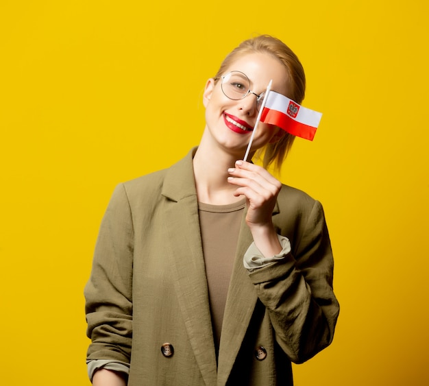 Stil blonde Frau in Jacke mit polnischer Flagge auf gelb