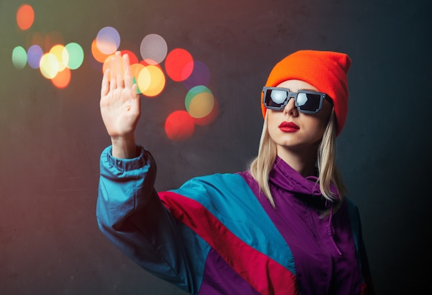 Stil Frau im Sportanzug und Sonnenbrille auf dunkler Wand