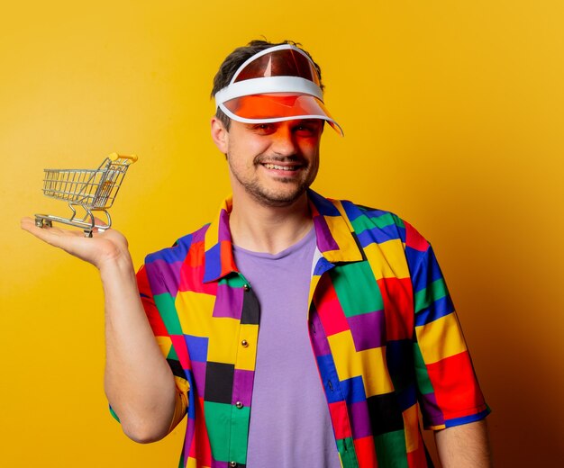 Stil Kerl in 90er Jahre Hemd und Hut mit kleinen Wagen in der Hand