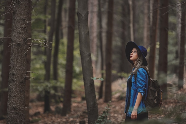 Stil Mädchen im Hut mit Rucksack in einer Sommerzeit Gemischter Nadelwald