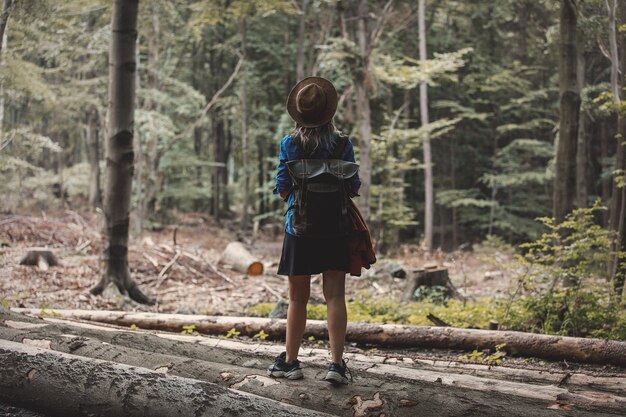 Stil Mädchen im Hut mit Rucksack in einer Sommerzeit Gemischter Nadelwald