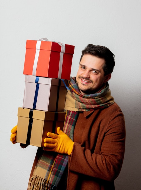 Stil Mann in Mantel und Schal mit Geschenkboxen