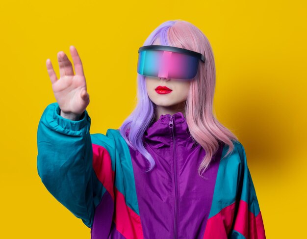 Stilfrau in VR-Brille und 90er Sportanzug auf gelbem Hintergrund