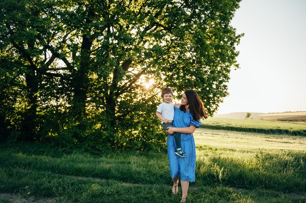 Stilische Mutter und hübscher Sohn, die Spaß an der Natur haben. Glückliches Familienkonzept.