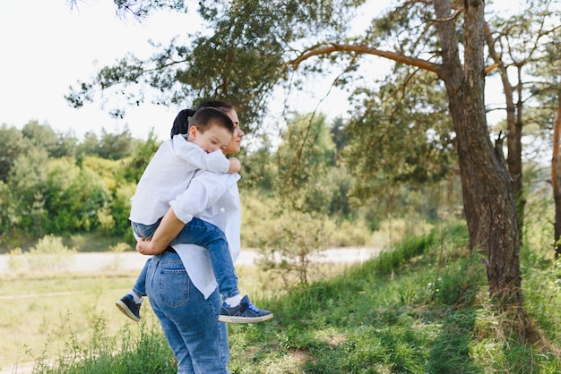 Stilish madre e hijo guapo divirtiéndose en la naturaleza