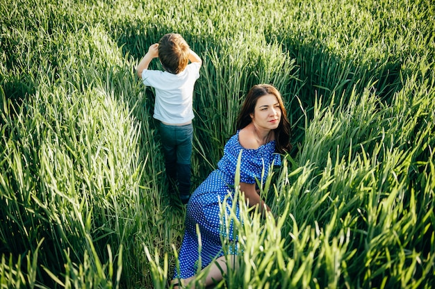 Stilish madre e hijo guapo divirtiéndose en la naturaleza.