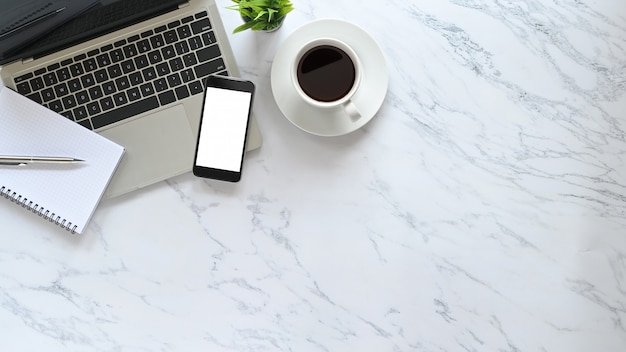 Stilisierte Marmor Büro Schreibtisch flach legen Laptop, Stift, Notizbuch, Kaffee mit Pflanze und Modell Telefon auf Draufsicht Kopierraum.